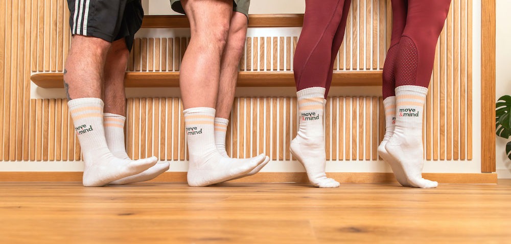 Krafttraining-HH-Harburg-Move-and-Mind Aufnahme der Füße von zwei Männern und zwei Frauen auf Socken - Männer ziehen Fußspitzen an, Frauen auf den Zehenspitzen