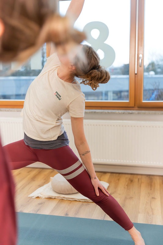 Krieger-Yogauebung Yogateilnehmerin in Kriegerhaltung